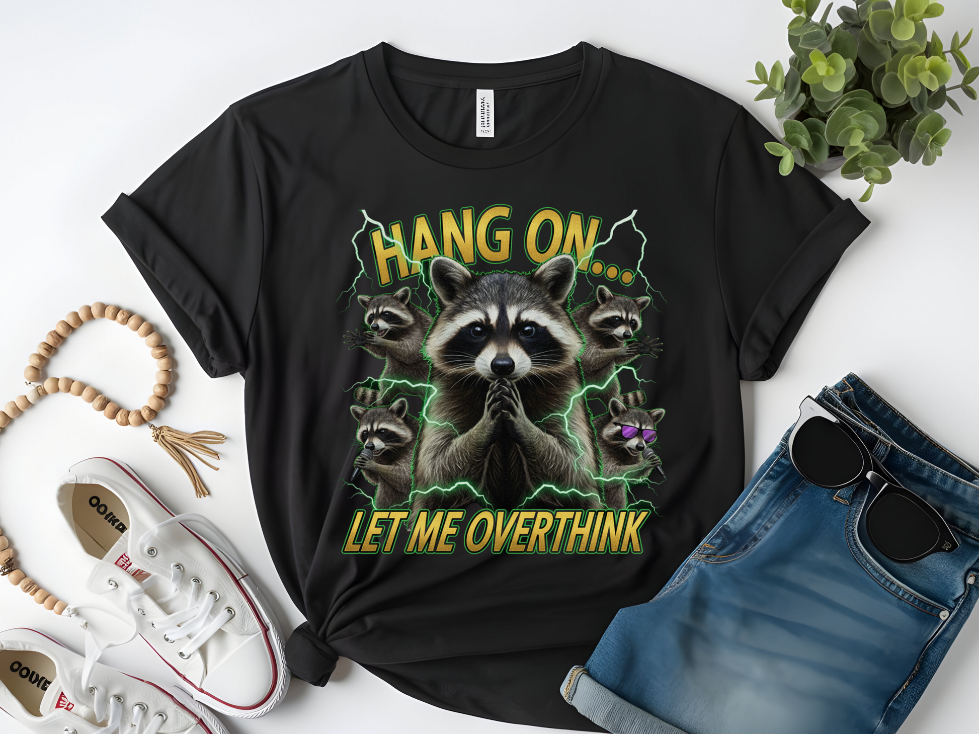 Black t-shirt with raccoon graphic and text 'Hang on, let me overthink' on a white background.